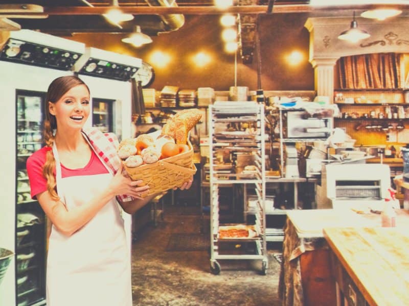 baker holding a basket of bread in a bakery