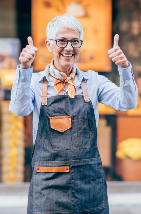 woman giving thumbs up while at work in a warehouse