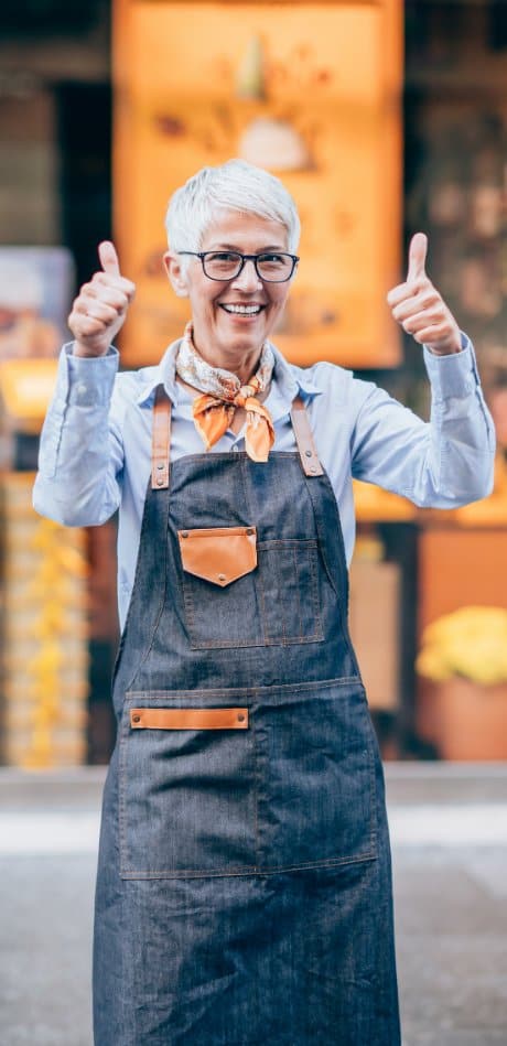 woman giving thumbs up while at work in a warehouse